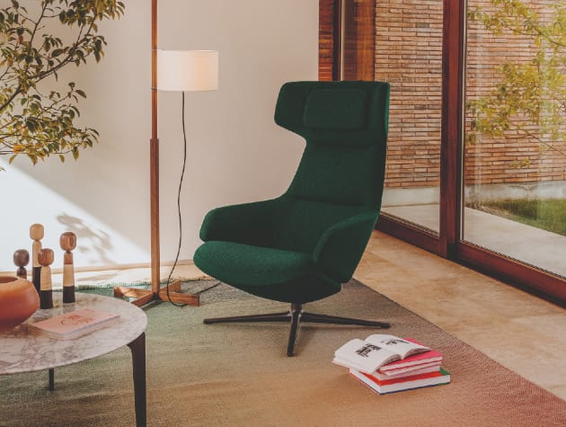 dark green fabric chair with lamp and table