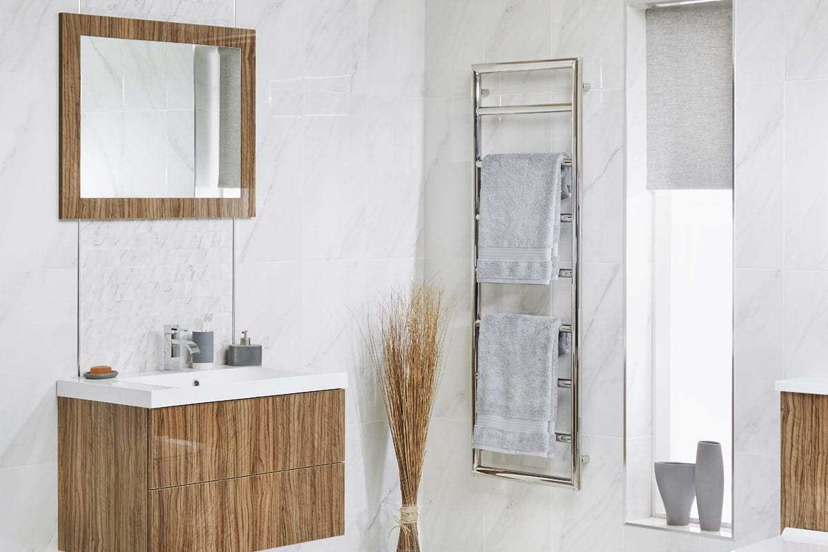 bathroom in white and brown with towel rail, plants, mirror and tiles