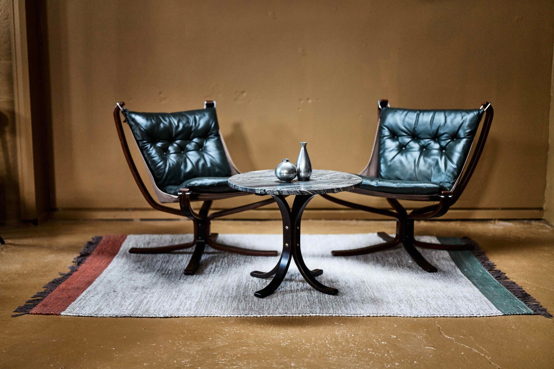 Two black leather chairs and round table